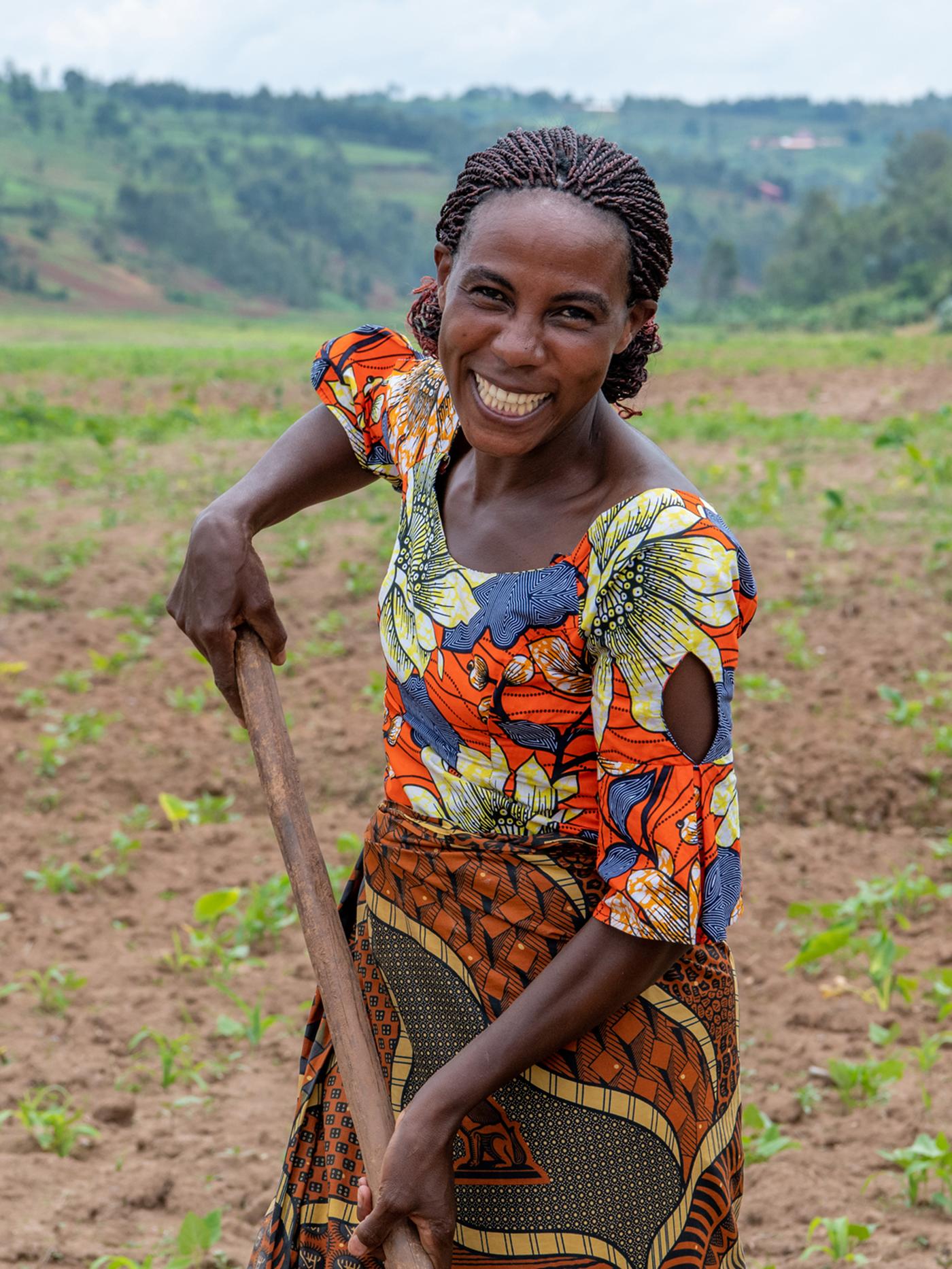 Portrait of Clementine, a Congolese refugee, smiling at the camera wearing a colourful pattern?