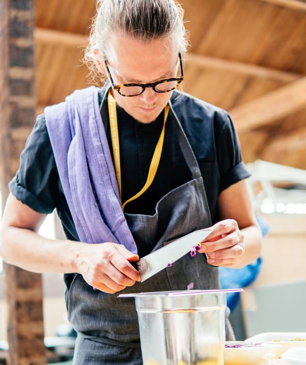 Portrait of David Johansson slicing onions.