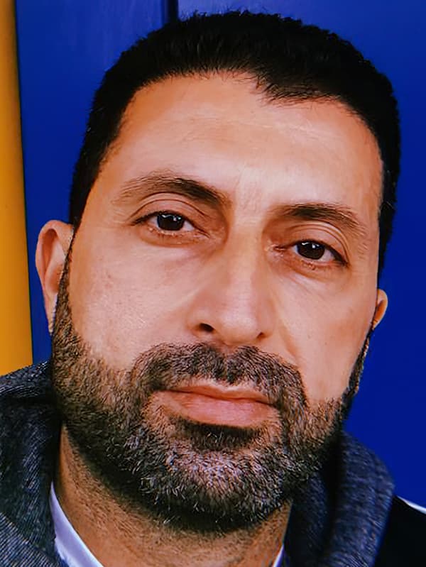 Portrait of Odai, an Iraqi refugee and IKEA Switzerland co-worker, against a yellow and blue background.
