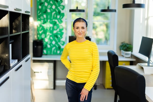 Portrait of woman standing in a bright modern office with yellow and green interior accents