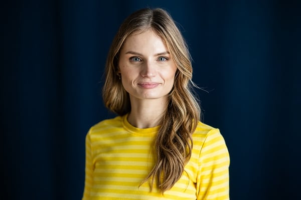 Портрет женщины в желтой полосатой рубашке на темно-синем фоне