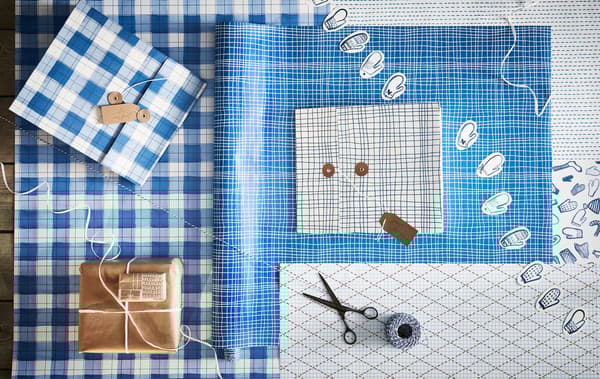 Poste d’emballage de cadeaux et ses accessoires: papiers de couleurs et de motifs variés, ficelles, ciseaux, étiquettes et boîtes-cadeaux. 