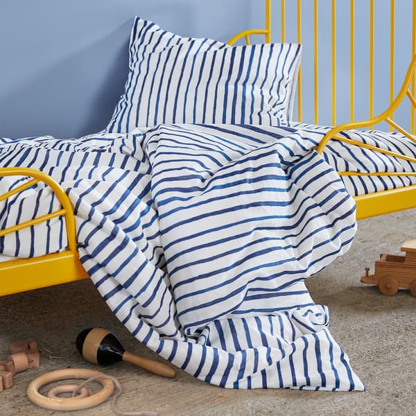 Posteľné obliečky SÅNGLÄRKA s modro-bielymi pásikmi na detskej posteli.