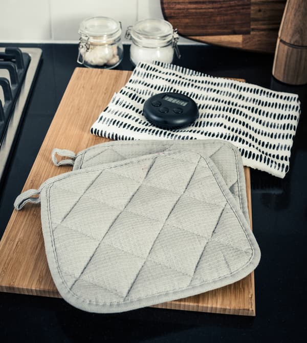 Pot holders and a timer on a kitchen counter.