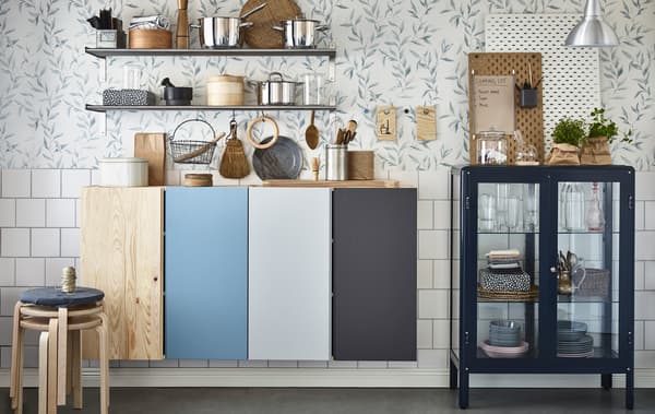 Pour organiser une maison partagée, utilise des peintures de différentes couleurs pour chaque colocataire, à l'intérieur et à l'extérieur des armoires de cuisine, sur des sous-plats utilisés comme tableaux à messages et derrière les étagères de salle de bain ouvertes.