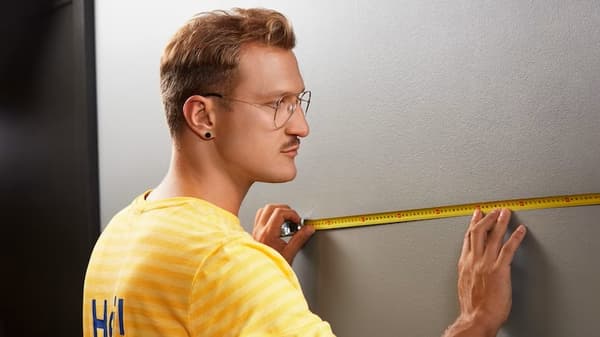 Pracownik IKEA mierzący ścianę.