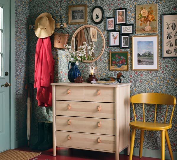 Predsieň s háčikmi na zavesenie šiat, žltou stoličkou a komodou BJÖRKSNÄS z masívneho brezového dreva s piatimi zásuvkami. 