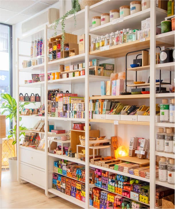 Prestatgeries plenes de productes naturals i cosmètics ben organitzats en una botiga lluminosa i acollidora.