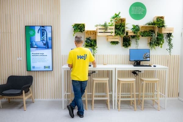 Prikaz notranjosti Studia za načrtovanje in naročanje IKEA Maribor: zaposleni načrtuje na računalniku.