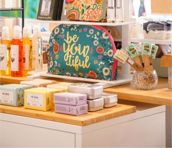 Primer pla de productes naturals i cosmètics en una botiga, amb una bossa decorativa.