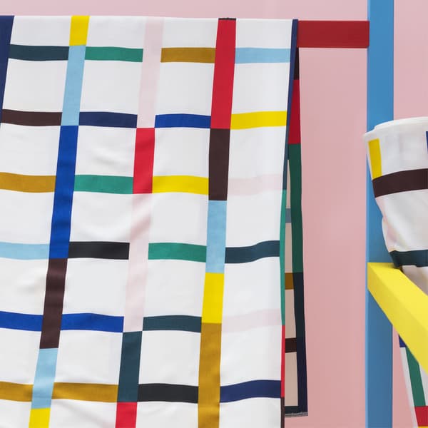 Primer pla d'una tela amb estampat multicolor que està penjada a una barra.