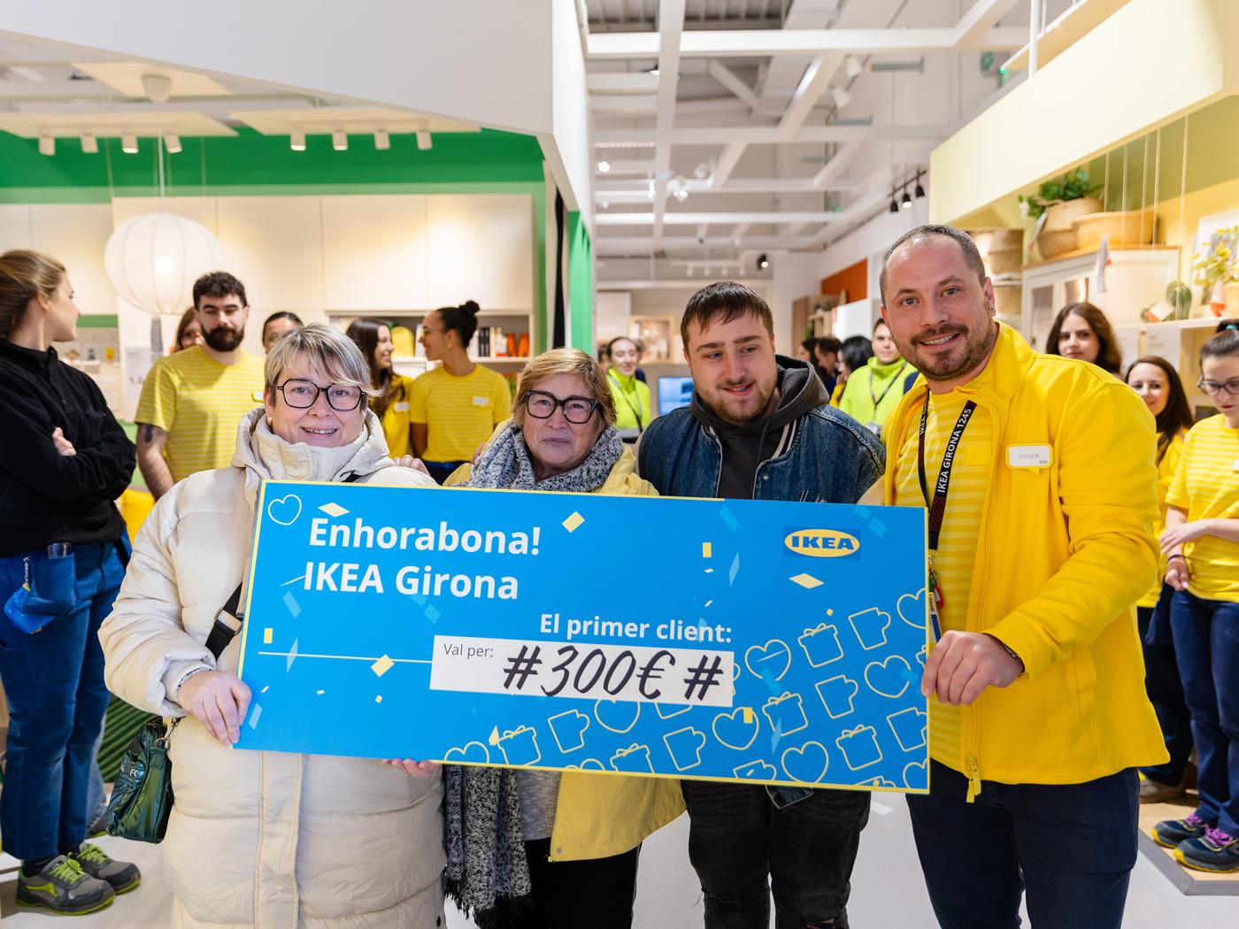 Primeros clientes del nuevo IKEA Girona posando con el cheque de premio al primer visitante de la tienda.