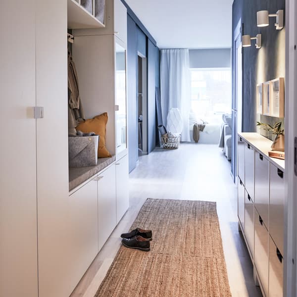 Proba unha solución de almacenaxe flexible que se adapte aos teitos de faiado e aos recibidores estreitos, como o armario branco PLATSA de IKEA.