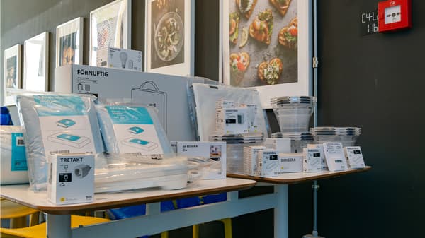 Prodotti IKEA per il risparmio energetico disposti ordinatamente su due  tavoli.