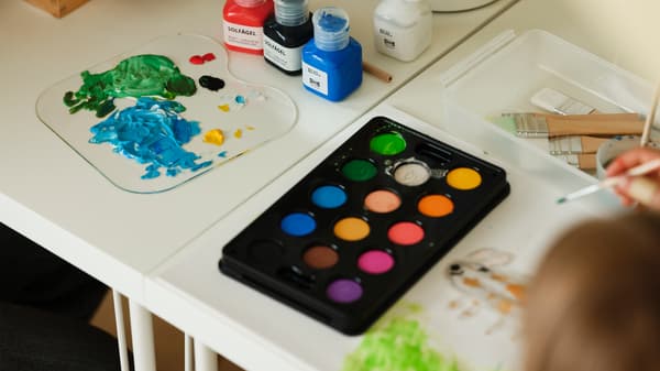 Products from MÅLA series like paint and watercolour box on the white table.