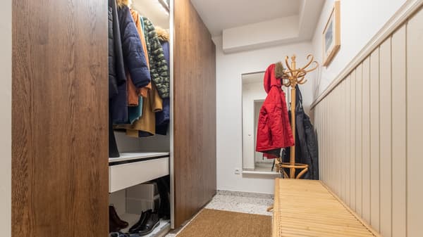 Przedpokój z brązową szafą PAX z drzwiami przesuwnymi.