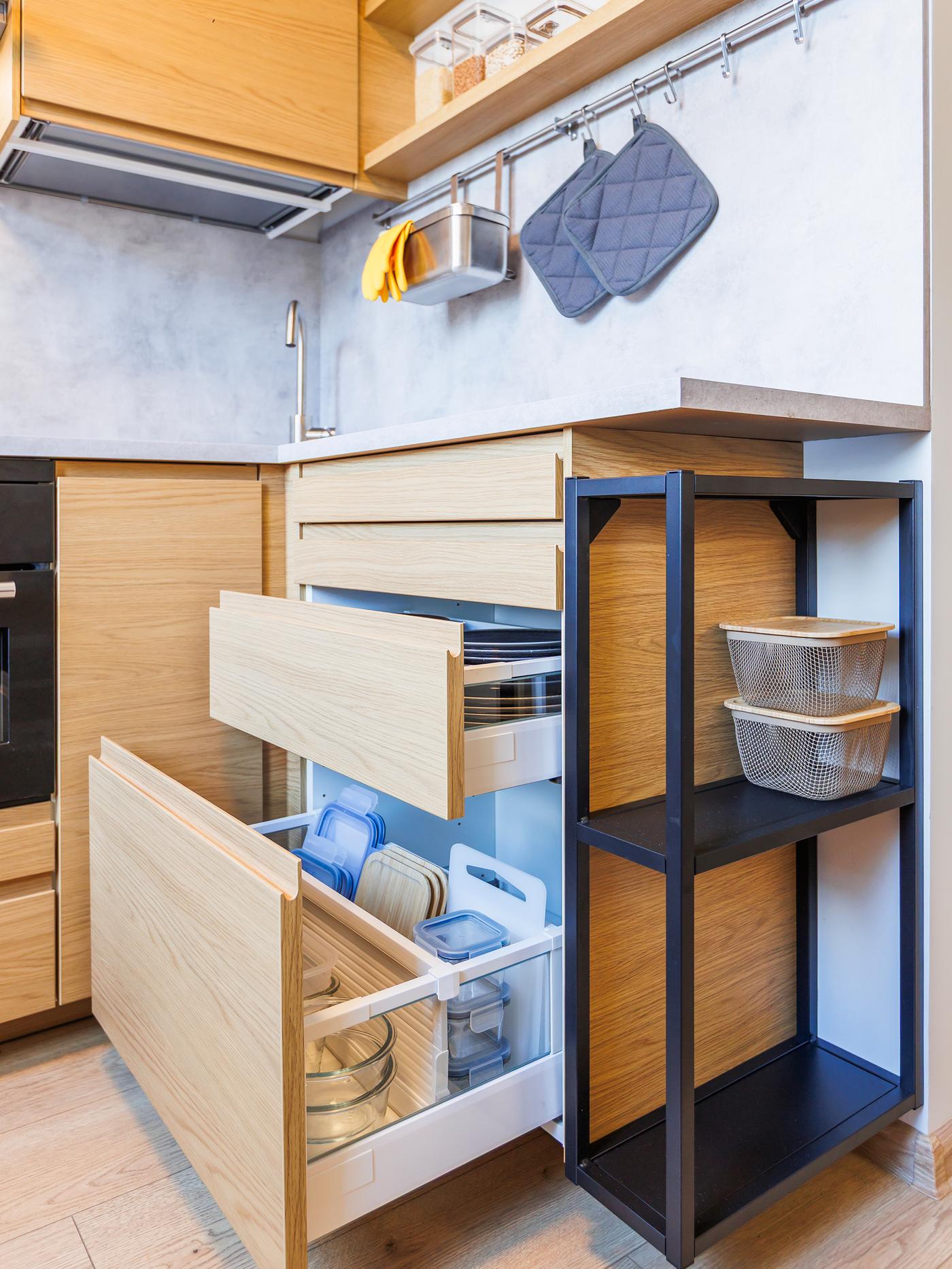Pull-out drawers showing an organised storage system with different compartments for dry goods and kitchen items.