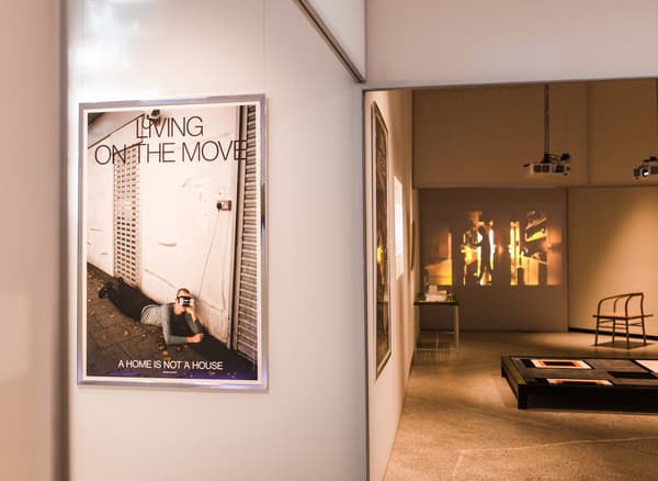 قسم من مساحة معرض بها صورة بعنوان 'Living on the move' على الحائط.