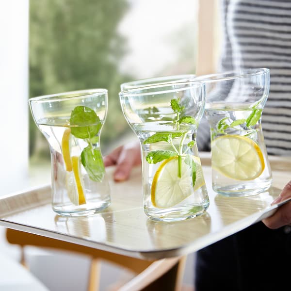 Quatre verres d’eau avec des rondelles de citron et des brins d’herbes aromatiques.