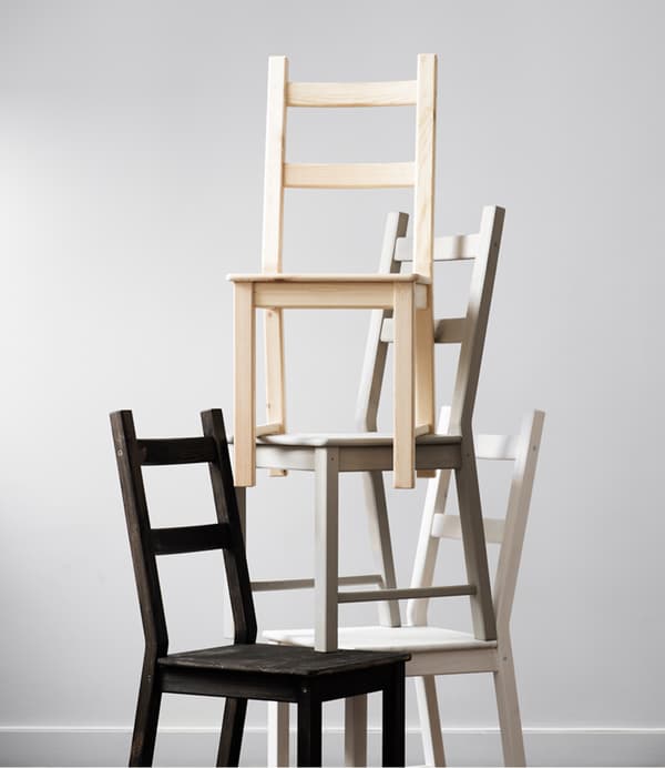 Quattro sedie IVAR superfici in legno naturale di diversi colori impilate come una piramide,