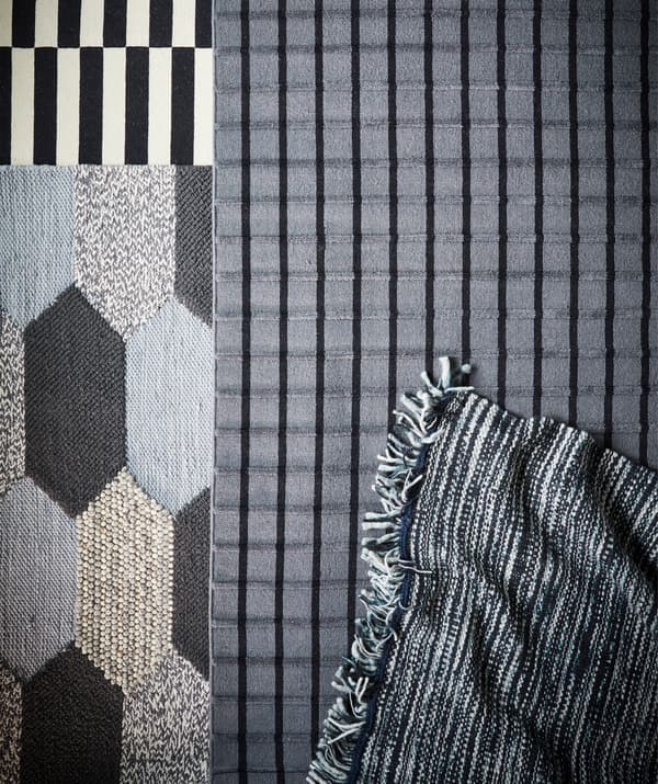 Quattro tappeti di fantasie diverse nei toni del grigio.