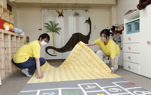ラグを広げるコワーカー。