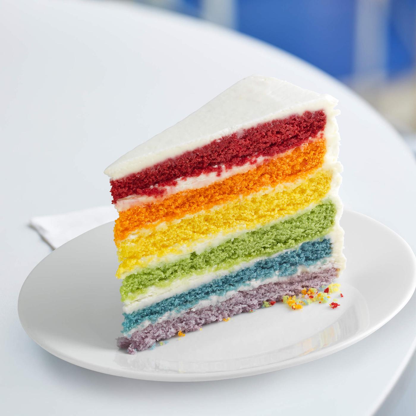 Rainbow cake sitting on a white plate.