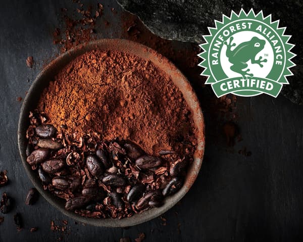 Rainforest Alliance 인증을 받은 코코아 원두와 그 원두를 갈아 만든 초콜릿 파우더로 채워진 수프볼과 Rainforest Alliance 로고