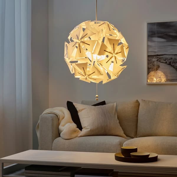 RAMSELE hvid loftlampe hænger i en stue over et sofabord og bagved står en sofa med puder 