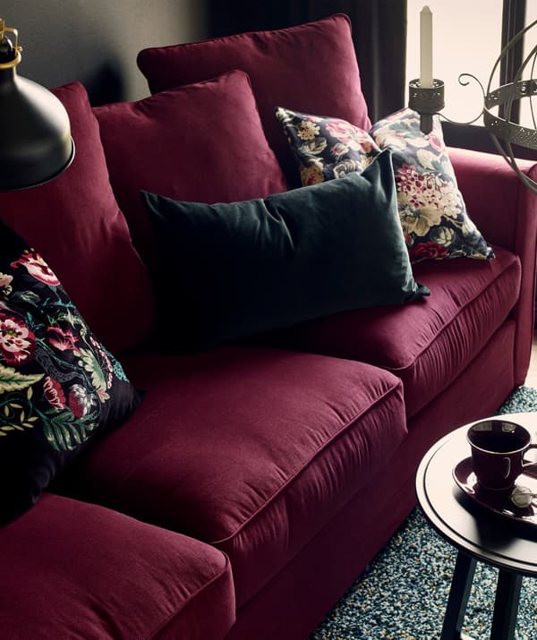 RANARP lamp beside a red sofa with cushions.