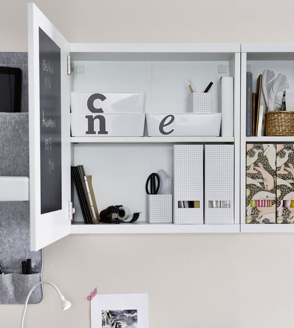 Rangement au-dessus d’un bureau, ouvert, avec boîtes de rangement étiquetées dedans.
