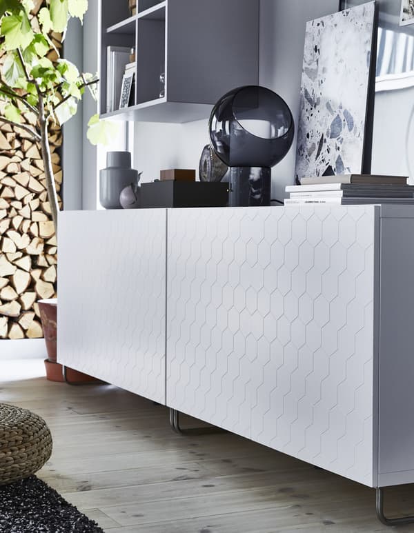 Rangement bas blanc avec porte à motif hexagonal.