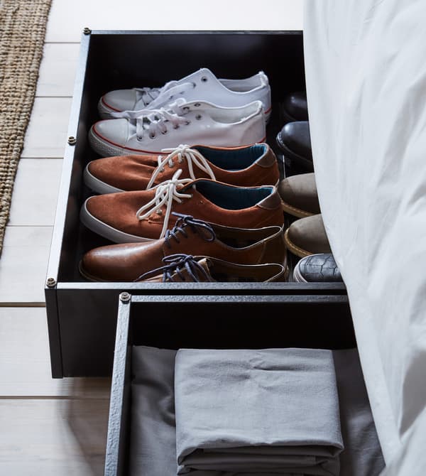 Rangements de lit remplis de chaussures et de linge de lit.
