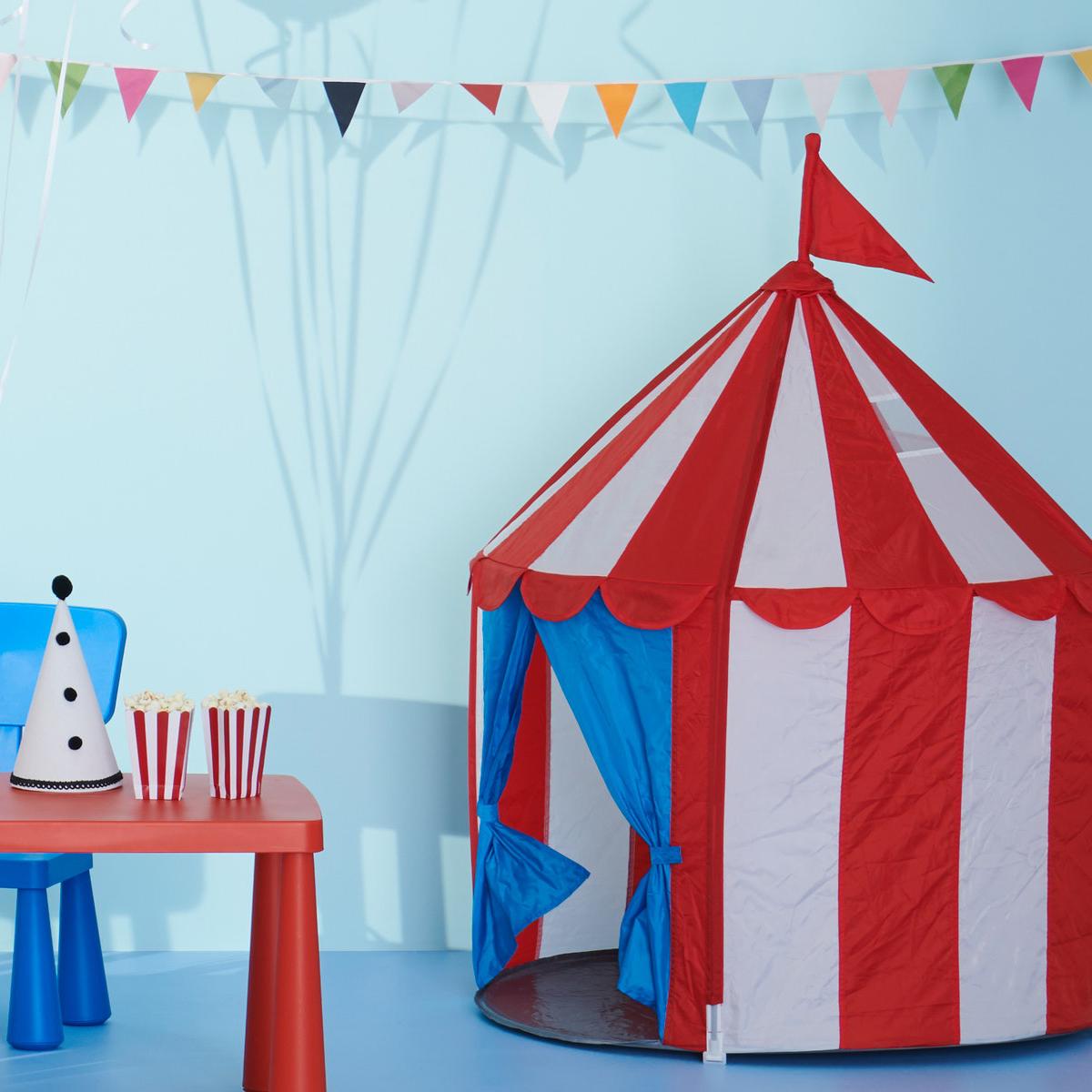 Rdeč in moder šotor za otroke pred modro steno. 