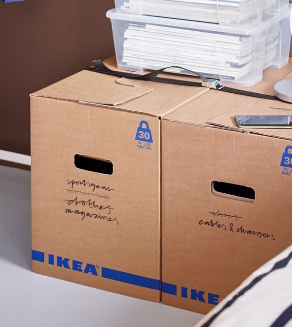 Recipientes transparentes cheos de papel sobre unhas caixas JÄTTENE con inscricións.