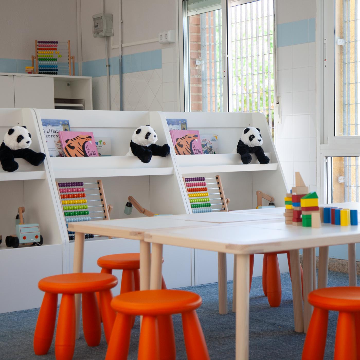 Recreational and reading space at an education centre with tables, stools and bookcases