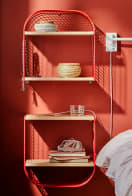 Red bookcase next to a bed