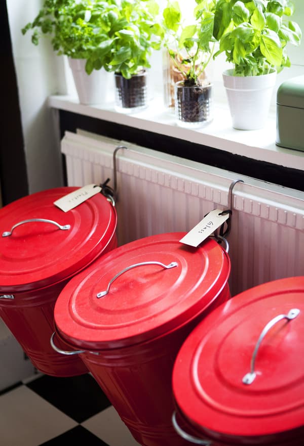 Red metal bins hang from the radiator to create an interesting and attractive recycling area.