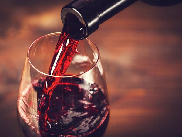 Red wine being poured into a wine glass.
