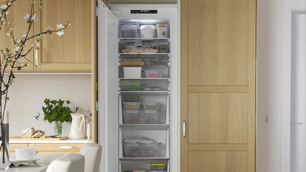Réfrigérateur ouvert, encastré dans une cuisine en bois clair