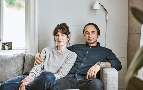 Rena และ Sam นั่งอยู่ด้วยกันที่โซฟาในโรงนาแบบสแกนดิเนเวียของพวกเขา