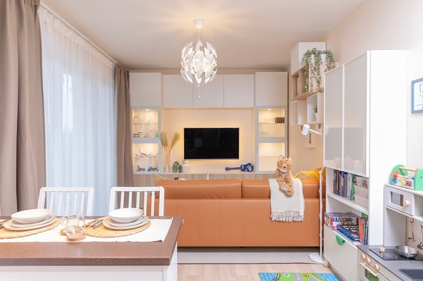 Renovated living room with leather sofa and TV wall unit.