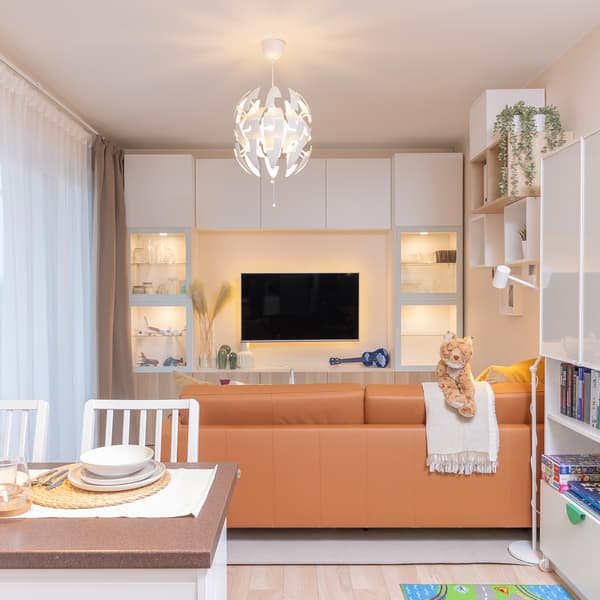 Renovated living room with leather sofa and TV wall unit.