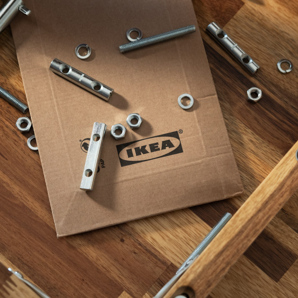 Reserveonderdelen liggen op een karton met het IKEA logo erop