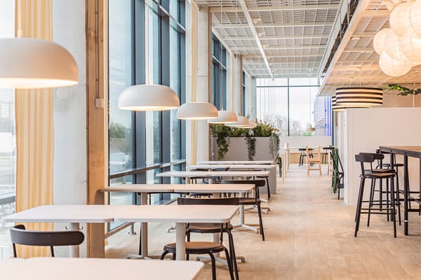 Restauracja IKEA. Białe stoły przy dużych oknach.