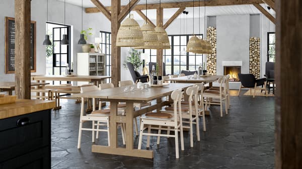 Restaurant i hyttestil med lange træborde, stole af træ, fritlagte træbjælker og pejs.