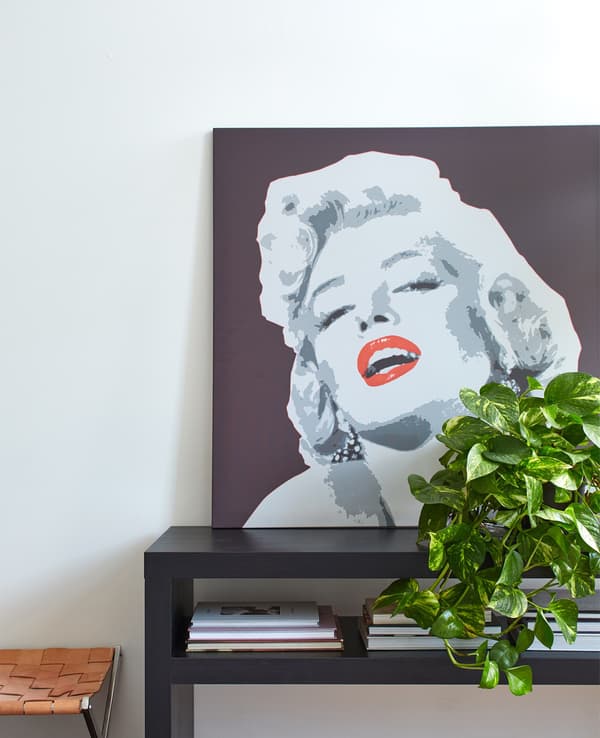 Retrat de la Marilyn Monroe a una taula de cafè negra, davant una paret blanca.