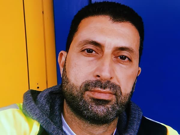 Retrat de l’Odai, refugiat iraquià i col·laborador d’IKEA a Suïssa, sobre un fons blau i groc.