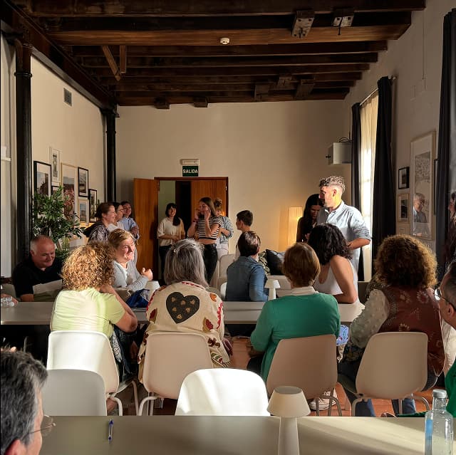 Reunión de vecinos en sala de centro social de Aroche.