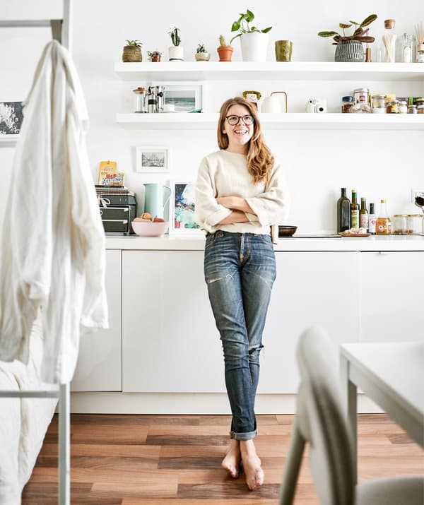 Rhianna standing in the all-white kitchen of her tiny apartment.